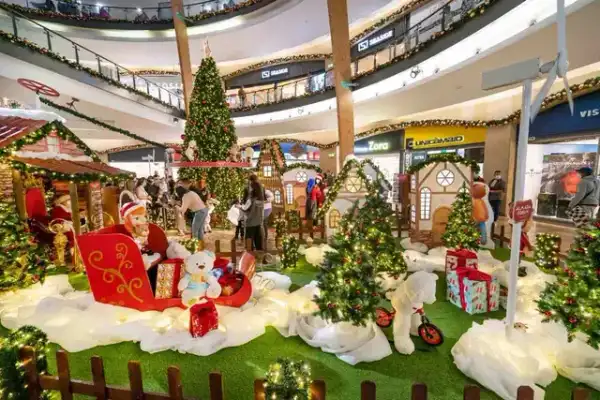 Cenário de Natal em centro comercial com trenó do Pai Natal, ursos de peluche e neve decorativa